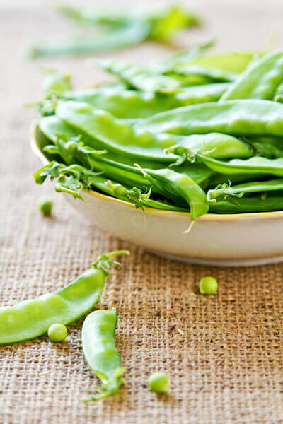 snow peas in a bowl on hession tablecloth